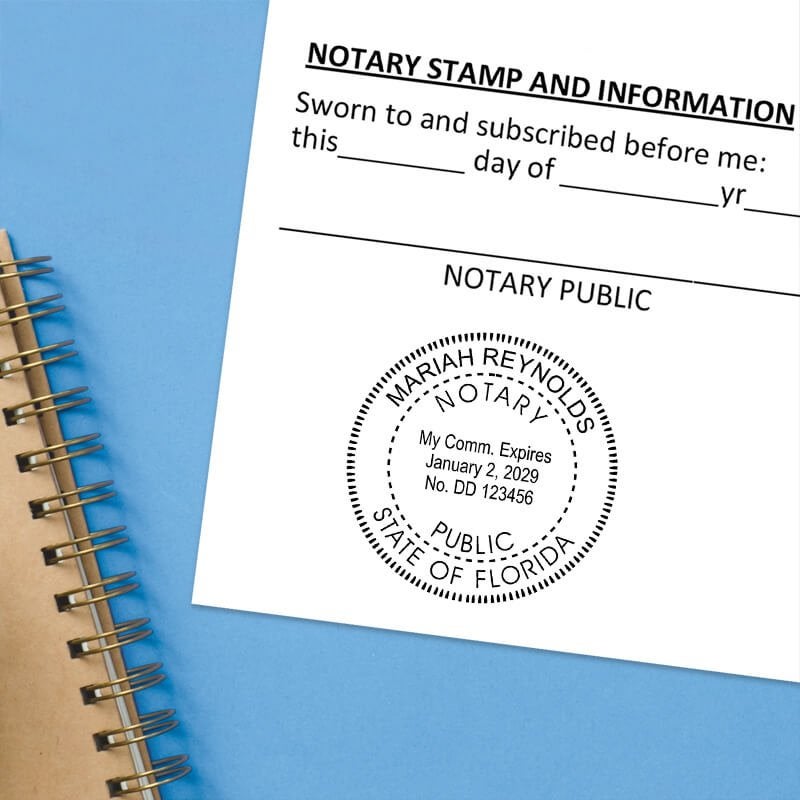 Florida notary stamp impression on white paper on a blue notebook. 