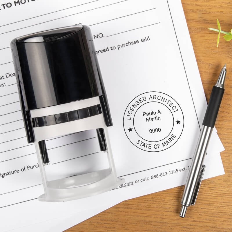 The State of Maine Architect Stamp Seal on a document next to a pen and self-inking stamp