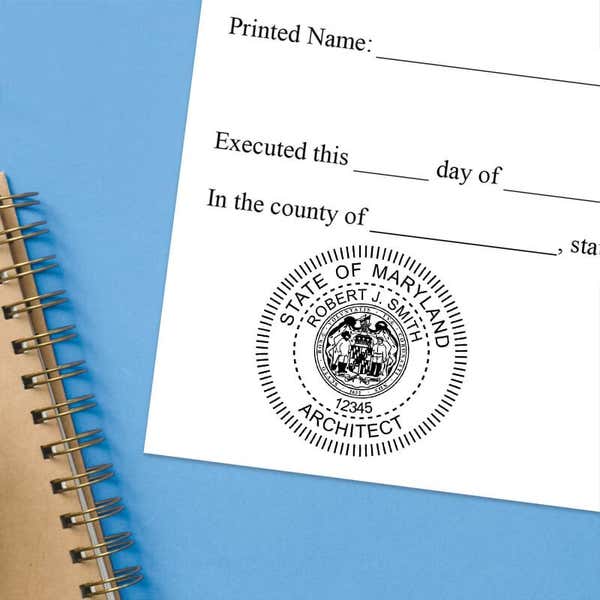 Maryland notary stamp impression on white paper on a blue notebook. 