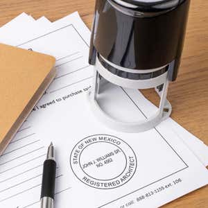 A self-inking stamp placed next to the State of New Mexico Architect Seal at the bottom of a document