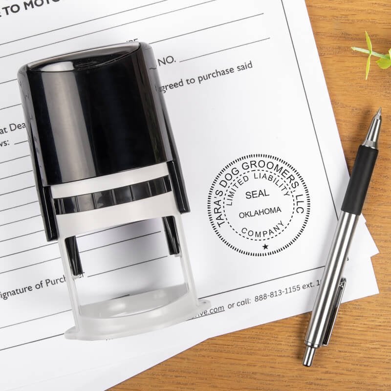 The State of Oklahoma LLC Corporate Seal on a document next to a pen and stamp body