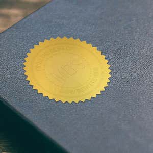 Example of Custom Initial Embosser Impression on Gold seal sticker on blue book