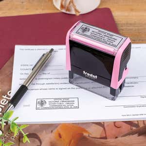Oregon Notary Pink Stamp Next Angle next to notary document with pen