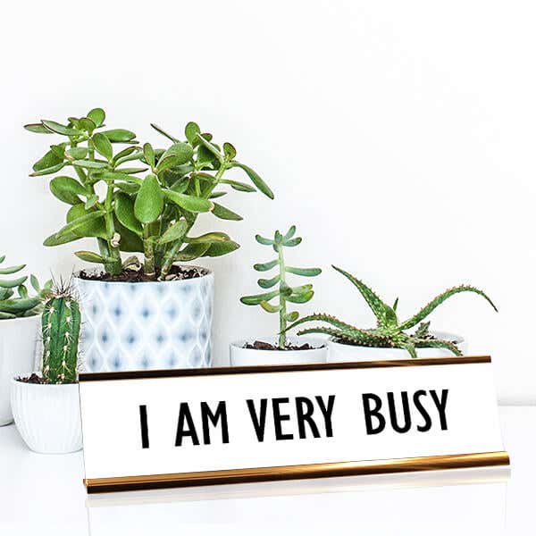 White desk plate with black custom text in rose gold holder on a desk