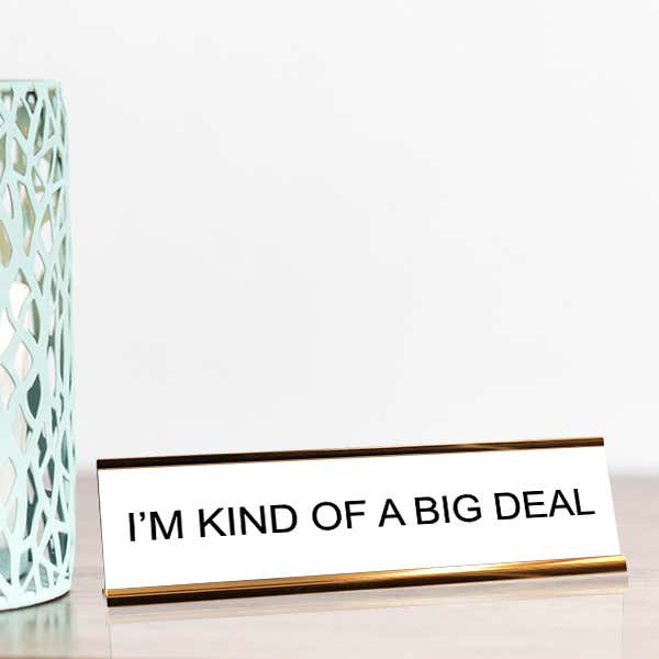 White desk plate with black custom text in a gold holder
