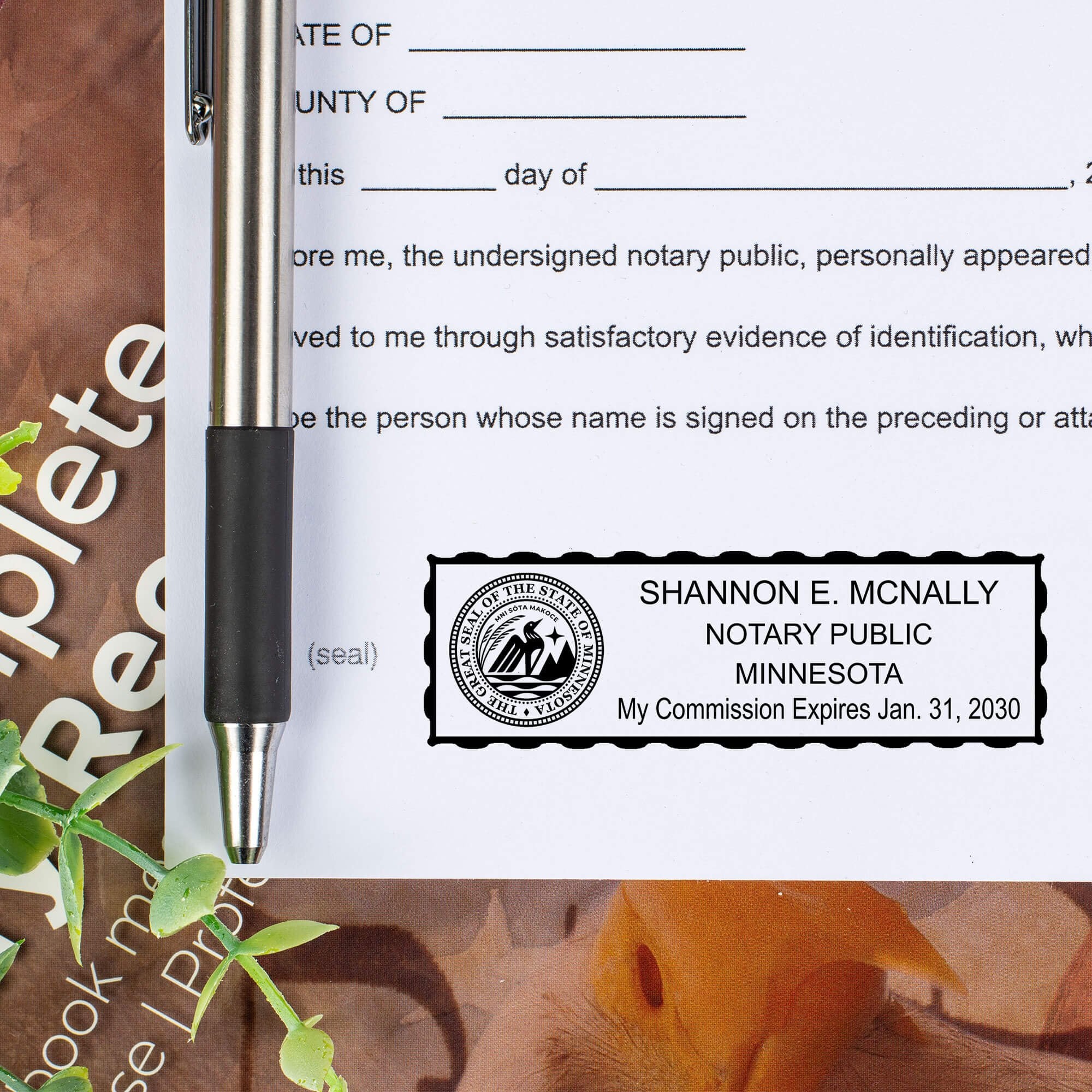 Minnesota Notary Seal Stamp on paper next to a pen