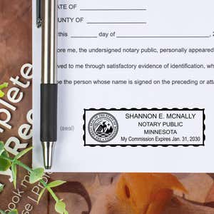 Minnesota Notary Seal Stamp on paper next to a pen