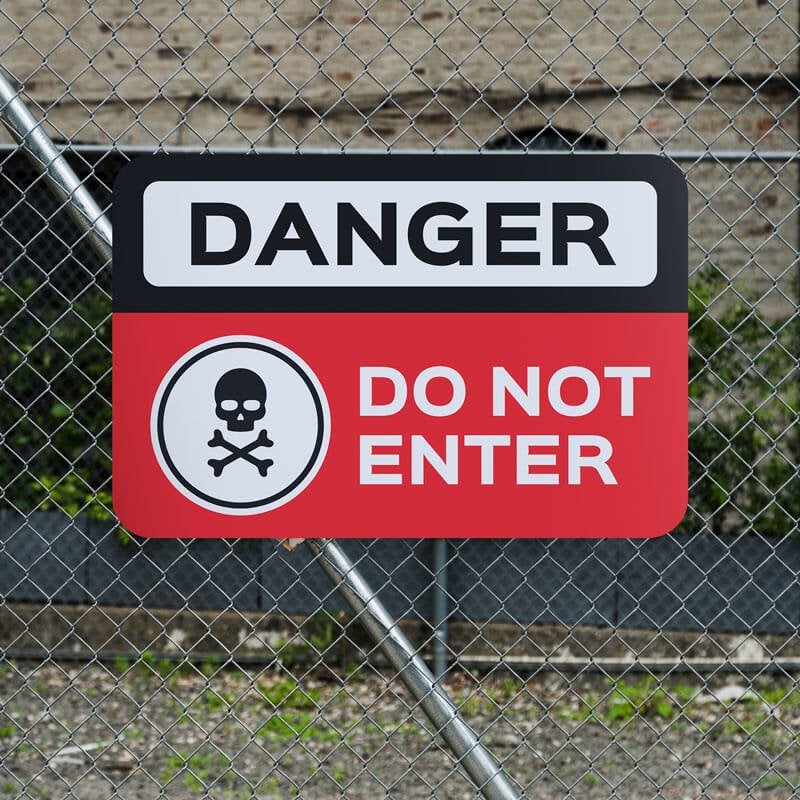 Danger Do Not Enter sign with skull image with red background with bold white and black text. Danger Do Not Enter sign with skull image with red background with bold white and black text.