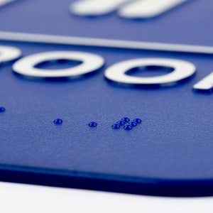 A close-up on the braille for the 9 x 6 ADA sign