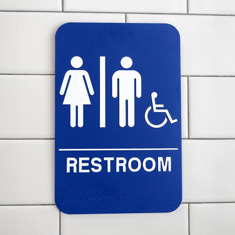 Blue Unisex Handicap Sign Hanging on a Wall