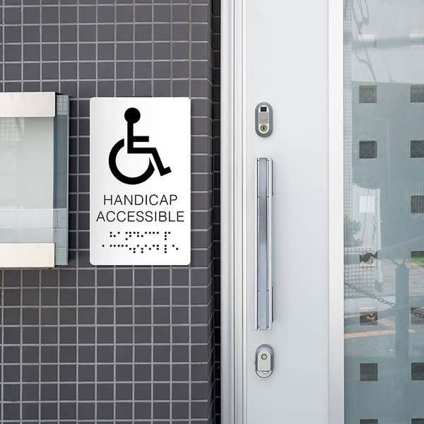 A white ADA sign for a handicap accessible entrance