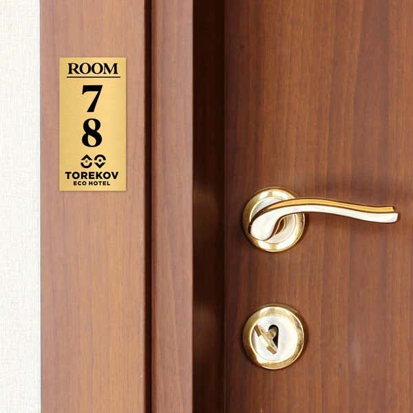 4x2 custom engraved brass sign displayed by a door