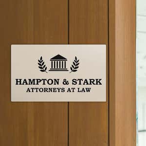 Engraved plastic sign displayed on a wooden wall