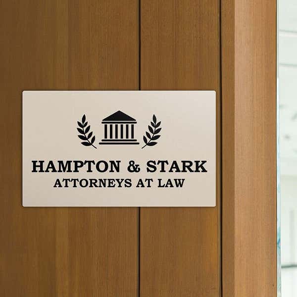 Engraved plastic sign displayed on a wooden wall