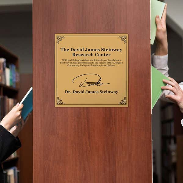 A gold plastic memorial sign for a research center