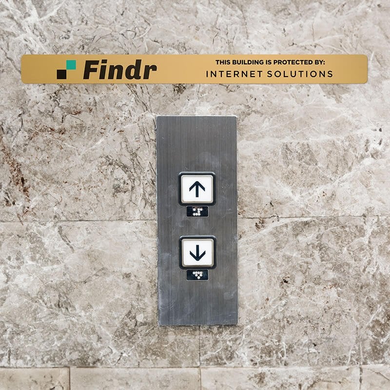 1x12 printed brass sign displayed above an elevator button