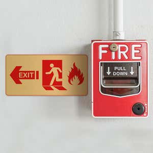 3x6 printed brass sign next to a fire alarm