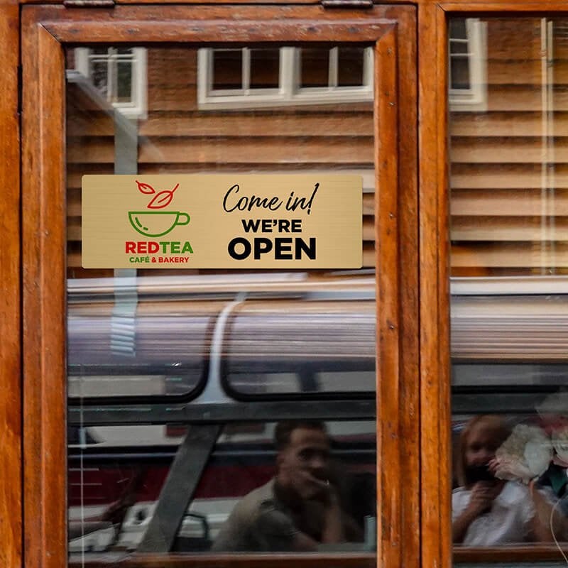 4x12 printed brass sign hanging on a glass door 4x12 printed brass sign hanging on a glass door