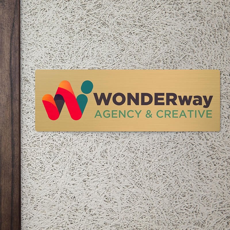 6x18 printed brass sign displayed by a doorway