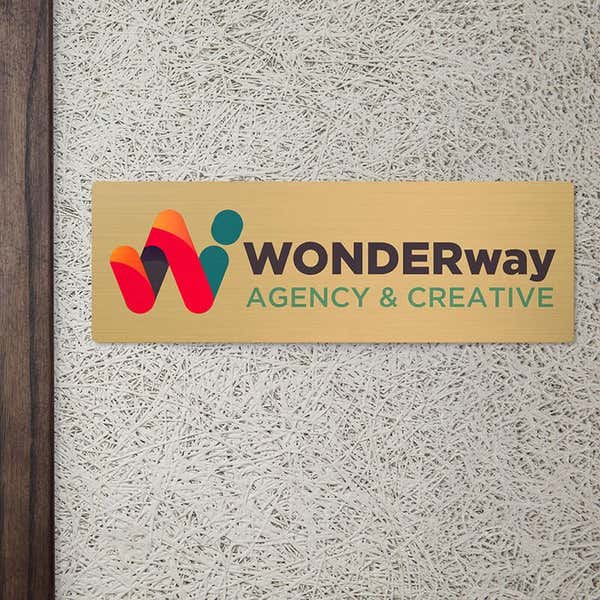 6x18 printed brass sign displayed by a doorway
