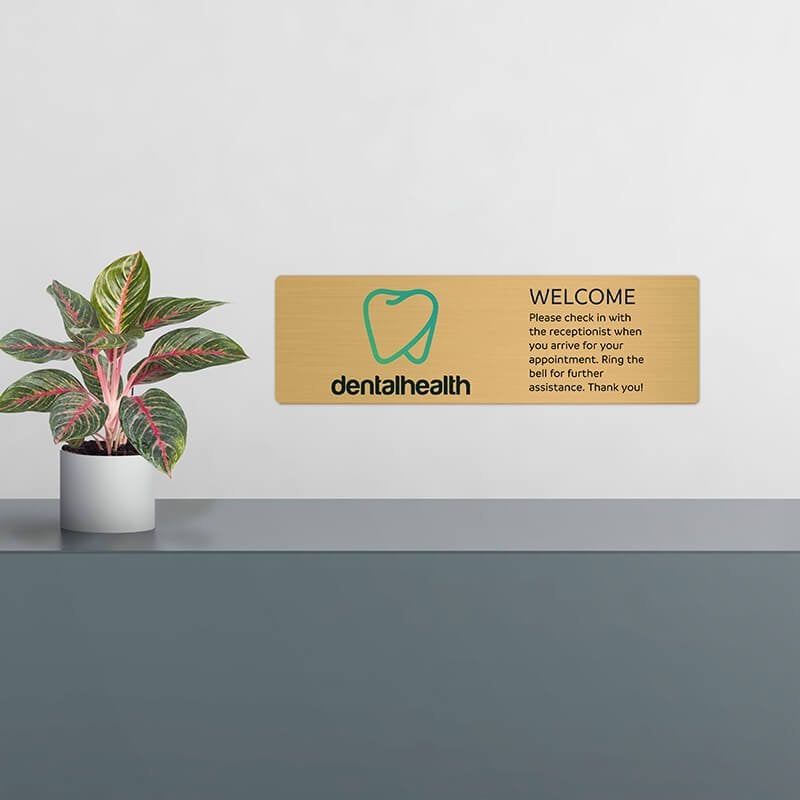 6x20 printed brass sign displayed by a front desk