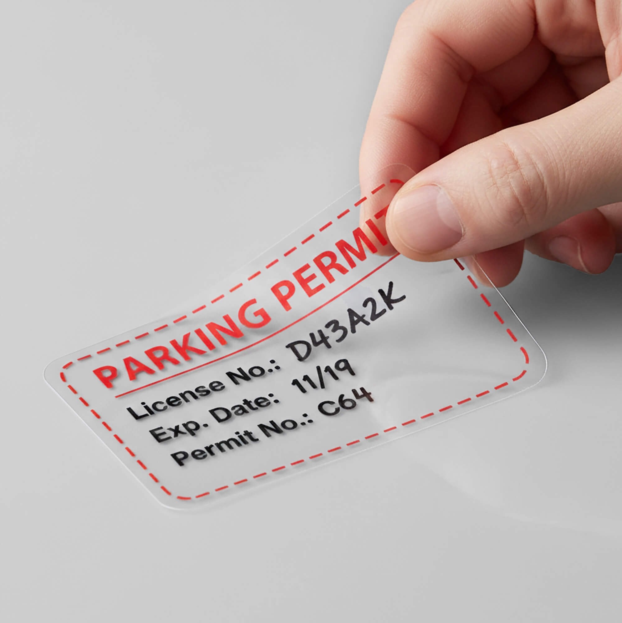 A window cling being peeled off a wall for a parking permit A window cling being peeled off a wall for a parking permit