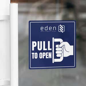 A blue window cling to pull to open on a glass door