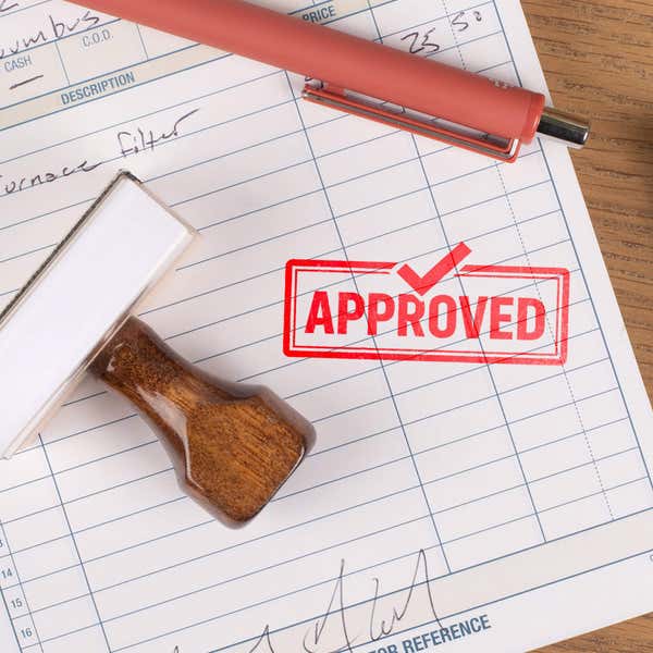 Wooden rubber stamp with approved imprint used for office paperwork approval