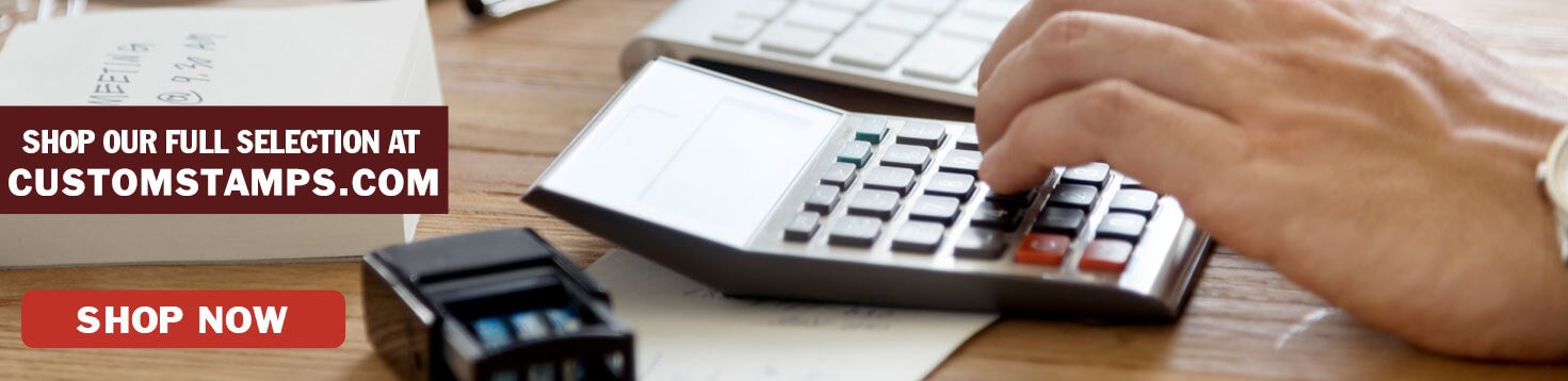 Person Using Calculator and Self-Inking Stamp on Table