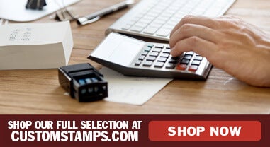 Person Using Calculator and Self-Inking Stamp on Table